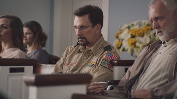 Movie still from “The Clovehitch Killer” (2018), directed by Duncan Skiles – A man in a uniform sitting at a table; Medium shot, Over the shoulder angle