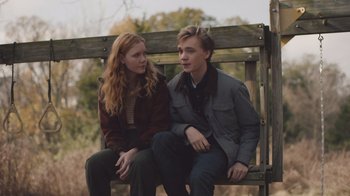 Movie still from “The Clovehitch Killer” (2018), directed by Duncan Skiles – A man and a woman sitting on a wooden bench; Medium shot, Over the shoulder angle