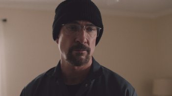 Movie still from “The Clovehitch Killer” (2018), directed by Duncan Skiles – A person wearing glasses and a hat; Close Up shot, Over the shoulder angle