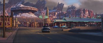 Movie still from “Cars 3” (2017), directed by Brian Fee – An old car is parked on the side of the road; Extreme Wide shot, Over the shoulder angle