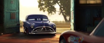 Movie still from “Cars 3” (2017), directed by Brian Fee – A car that is sitting in the dirt; Wide shot, Over the shoulder angle