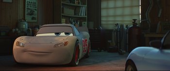 Movie still from “Cars 3” (2017), directed by Brian Fee – A car that is sitting in a garage; Medium shot, Low angle
