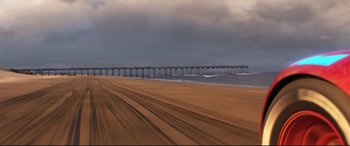 Movie still from “Cars 3” (2017), directed by Brian Fee – A beach with a pier in the background; Extreme Wide shot, Low angle