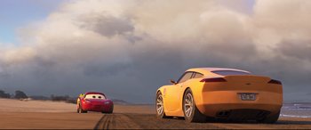Movie still from “Cars 3” (2017), directed by Brian Fee – A red and a yellow sports car on a dirt road under a cloudy sky; Wide shot, Low angle