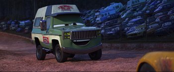 Movie still from “Cars 3” (2017), directed by Brian Fee – A green truck is parked in a parking lot; Wide shot, Low angle