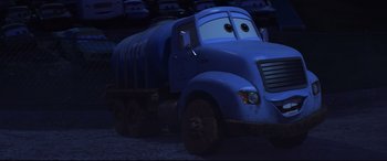 Movie still from “Cars 3” (2017), directed by Brian Fee – A large blue truck is parked in a parking lot; Wide shot, High angle