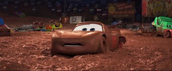 Movie still from “Cars 3” (2017), directed by Brian Fee – A car that is in the dirt with mud all over it; Wide shot, High angle