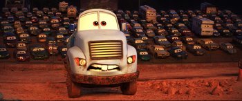Movie still from “Cars 3” (2017), directed by Brian Fee – A white truck is parked in a parking lot full of toy cars; Wide shot, Low angle
