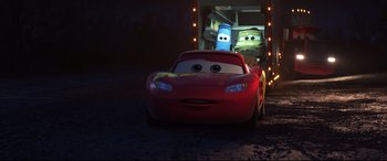 Movie still from “Cars 3” (2017), directed by Brian Fee – A red car is pulling a blue car behind it; Medium shot, Over the shoulder angle