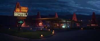 Movie still from “Cars 3” (2017), directed by Brian Fee – An old style gas station at night with lights on; Extreme Wide shot, High angle