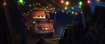 Movie still from “Cars 3” (2017), directed by Brian Fee – A car is parked in a garage with lights; Wide shot, Low angle