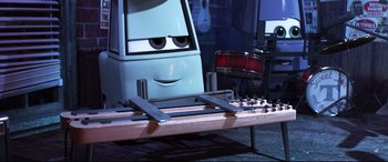 Movie still from “Cars 3” (2017), directed by Brian Fee – A table with a guitar and a guitar case on top of it; Close Up shot, Low angle