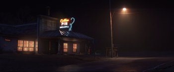 Movie still from “Cars 3” (2017), directed by Brian Fee – A neon sign on the side of a building at night; Extreme Wide shot, Low angle
