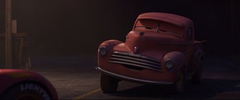 Movie still from “Cars 3” (2017), directed by Brian Fee – An old red car parked on the side of the road; Close Up shot, Low angle