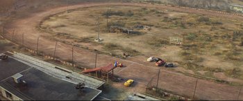 Movie still from “Cars 3” (2017), directed by Brian Fee – An aerial view of an empty parking lot with cars parked on it; Extreme Wide shot, High angle