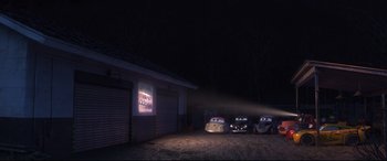 Movie still from “Cars 3” (2017), directed by Brian Fee – A group of cars parked in front of a movie screen; Wide shot, High angle