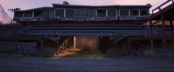 Movie still from “Cars 3” (2017), directed by Brian Fee – An abandoned car parked in the middle of a dirt road; Extreme Wide shot, High angle