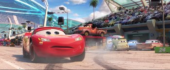 Movie still from “Cars 3” (2017), directed by Brian Fee – A group of cars in a parking lot with palm trees in the background; Wide shot, Low angle