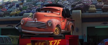 Movie still from “Cars 3” (2017), directed by Brian Fee – A red truck is parked in a parking lot; Medium shot, Low angle