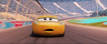 Movie still from “Cars 3” (2017), directed by Brian Fee – A yellow race car driving down a race track; Close Up shot, Low angle