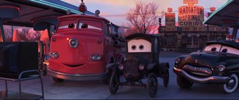 Movie still from “Cars 3” (2017), directed by Brian Fee – A tow truck and a car in a scene from cars; Wide shot, Low angle