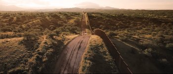 An aerial view of a dirt road near a wall