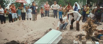 Movie still from “Cartel Land” (2015), directed by Matthew Heineman – A man kneeling down next to an empty casket; Wide shot, High angle