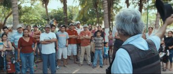 Movie still from “Cartel Land” (2015), directed by Matthew Heineman – A group of people standing in front of a group of trees; Medium shot, Over the shoulder angle