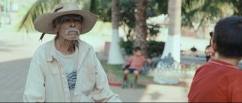Movie still from “Cartel Land” (2015), directed by Matthew Heineman – An older man wearing a hat and a white shirt; Medium shot, Over the shoulder angle