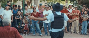 Movie still from “Cartel Land” (2015), directed by Matthew Heineman – A group of people standing around a crowd of people; Wide shot, Over the shoulder angle