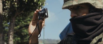 Movie still from “Cartel Land” (2015), directed by Matthew Heineman – A man holding a camera up to his face; Close Up shot, Low angle