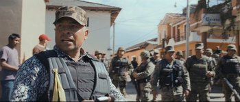 Movie still from “Cartel Land” (2015), directed by Matthew Heineman – A group of men standing next to each other on a street; Medium shot, Over the shoulder angle