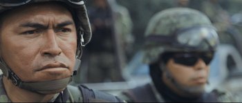 Movie still from “Cartel Land” (2015), directed by Matthew Heineman – Two soldiers in uniform are sitting in a vehicle; Close Up shot, Over the shoulder angle