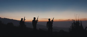 Movie still from “Cartel Land” (2015), directed by Matthew Heineman – A group of men standing on top of a hill holding guns; Wide shot, Low angle