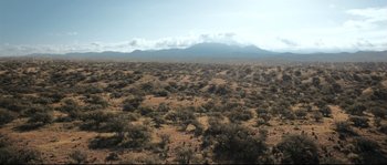 Movie still from “Cartel Land” (2015), directed by Matthew Heineman – An open field with a mountain in the background; Extreme Wide shot, High angle