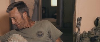 Movie still from “Cartel Land” (2015), directed by Matthew Heineman – A man sitting in front of a window wearing a t - shirt; Close Up shot, Over the shoulder angle