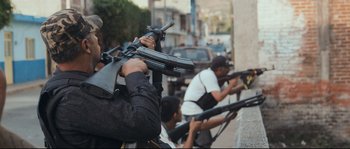 Movie still from “Cartel Land” (2015), directed by Matthew Heineman – A group of men holding guns on top of a street; Medium shot, Low angle