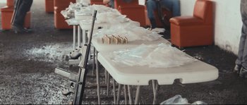Movie still from “Cartel Land” (2015), directed by Matthew Heineman – A table that has a gun on top of it; Medium shot, High angle