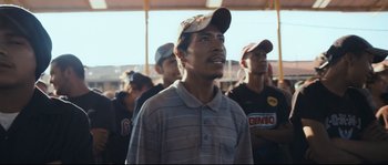 Movie still from “Cartel Land” (2015), directed by Matthew Heineman – A group of men standing next to each other in a stadium; Medium shot, Low angle