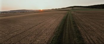 Movie still from “Cartel Land” (2015), directed by Matthew Heineman – An aerial view of an empty field with a sunset in the background; Extreme Wide shot, High angle
