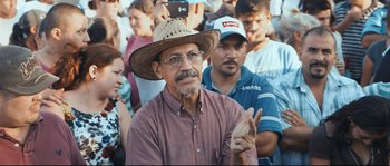 Movie still from “Cartel Land” (2015), directed by Matthew Heineman – An older man wearing a straw hat and glasses; Medium shot, Over the shoulder angle
