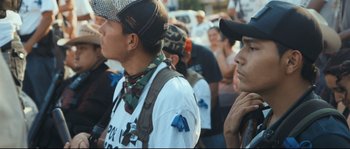 Movie still from “Cartel Land” (2015), directed by Matthew Heineman – A group of people standing next to each other on a street; Medium shot, High angle
