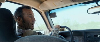 Movie still from “Cartel Land” (2015), directed by Matthew Heineman – A man driving a car in the middle of the day; Close Up shot, Over the shoulder angle