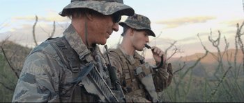 Movie still from “Cartel Land” (2015), directed by Matthew Heineman – Two men in military uniforms are standing next to each other; Close Up shot, Over the shoulder angle