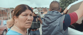 Movie still from “Cartel Land” (2015), directed by Matthew Heineman – A group of people standing next to each other on a street; Close Up shot, Over the shoulder angle