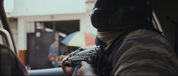 Movie still from “Cartel Land” (2015), directed by Matthew Heineman – A man holding a gun while standing next to an umbrella; Extreme Close Up shot, Low angle