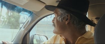 Movie still from “Cartel Land” (2015), directed by Matthew Heineman – An older man wearing a hat sitting in the driver's seat of a car; Close Up shot, Low angle