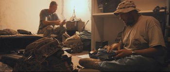 Movie still from “Cartel Land” (2015), directed by Matthew Heineman – A group of men sitting on the floor in a room; Medium shot, High angle
