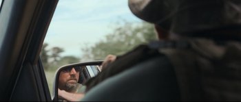 Movie still from “Cartel Land” (2015), directed by Matthew Heineman – A man looking at himself in the side view mirror of a car; Close Up shot, Over the shoulder angle