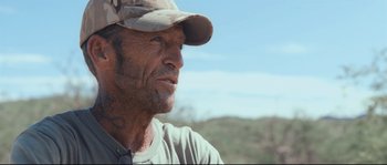 Movie still from “Cartel Land” (2015), directed by Matthew Heineman – A person wearing a hat; Close Up shot, Over the shoulder angle